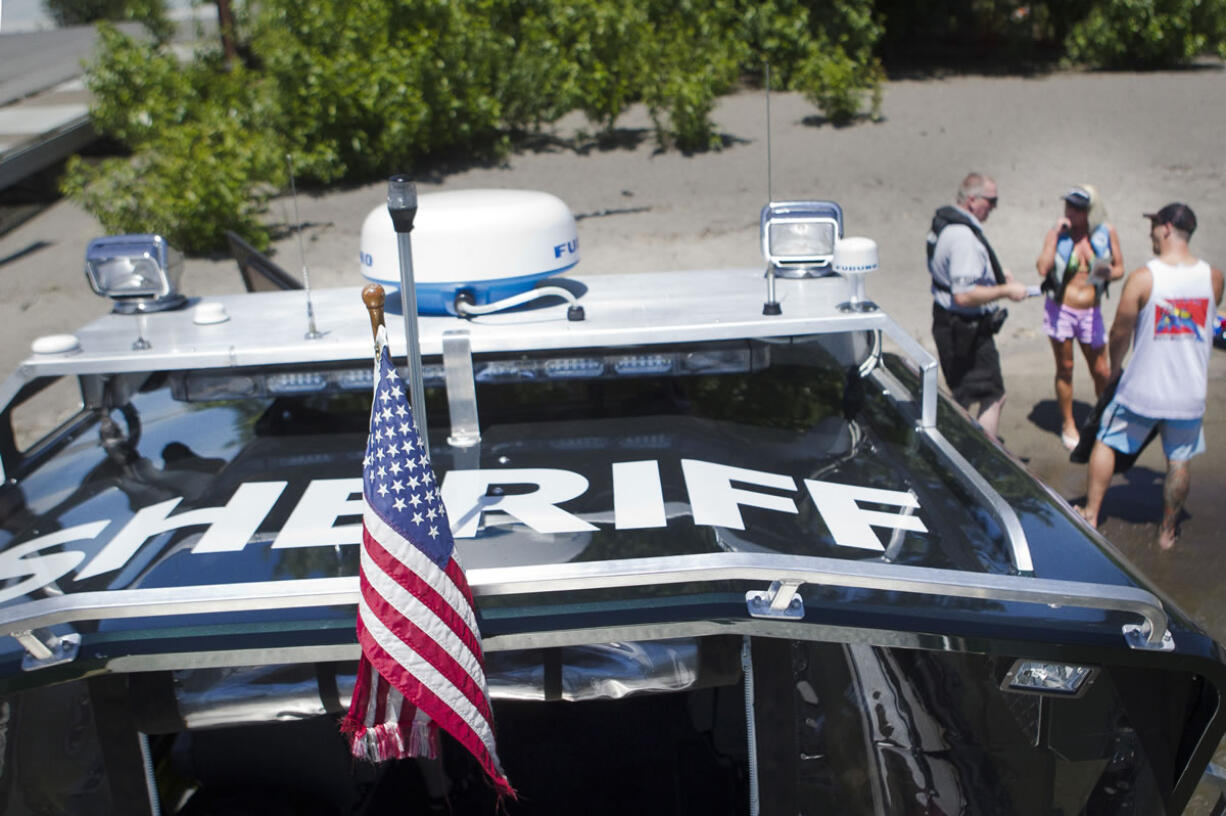 Clark County Sheriff's Deputy Kevin Gadaire explains to boaters the correct way to display their license on the side of their personal watercraft during a visit to the Marine Park boat launch Friday.