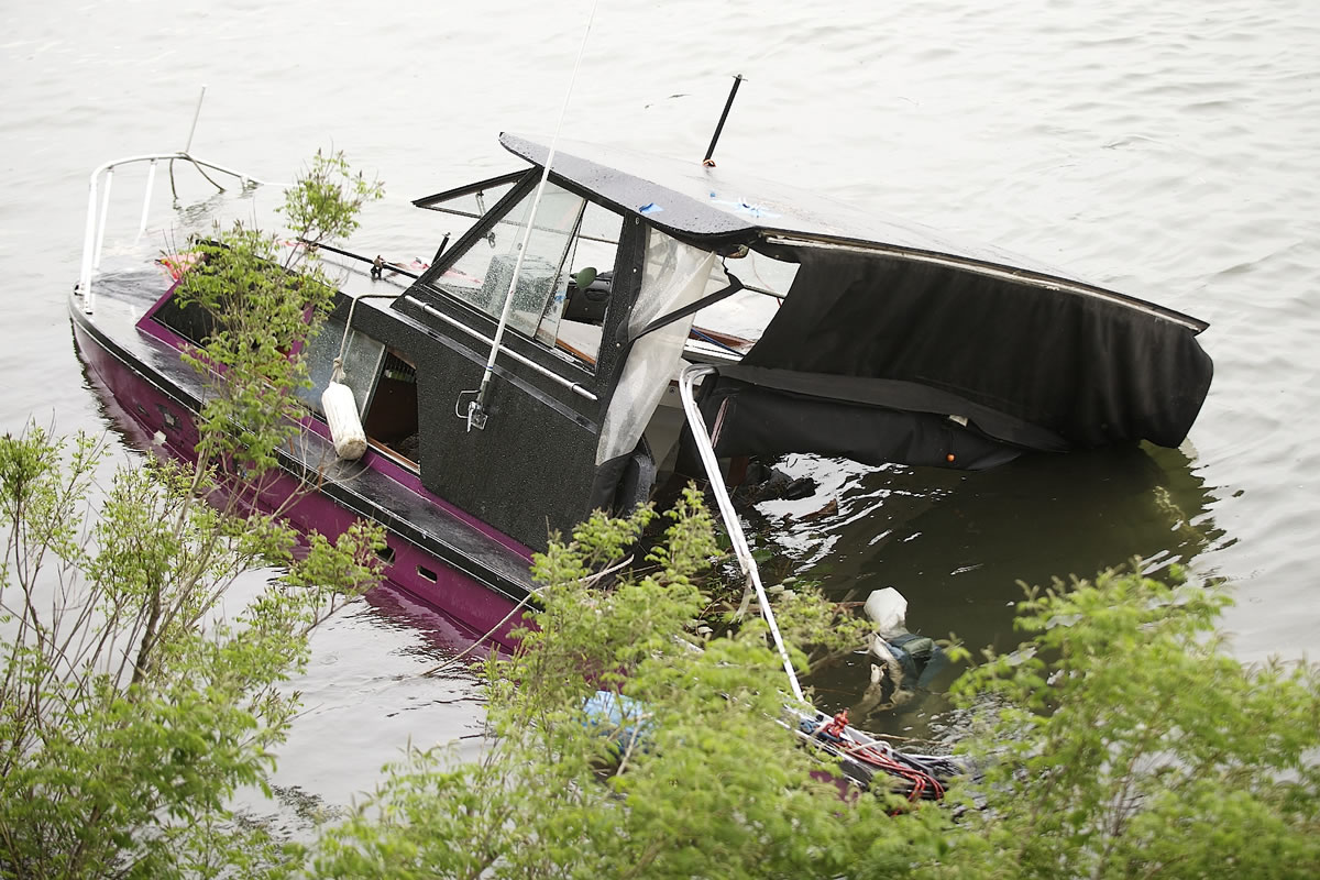 A partially submerged boat will likely remain along at the bank of the Columbia River near Who's Song and Larry's until mid-June.