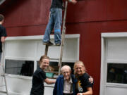 Salmon Creek: Courtney Wood, left, and Jordon Jackson, right, both of Vancouver, helped paint Walter Remme's garage during a massive volunteer effort by Mormon teens in Clark County.