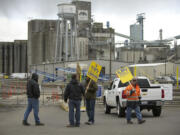 A small group representing locked out ILWU members picket outside a gate at the Port of Vancouver on Wednesday in Vancouver.