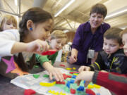 Teacher-librarian Kay Ellison helps Marshall Elementary School kindergartners, from left, Jadyn Christensen, Justine Franco, Brian Deming, Will Garrett and Andrew Banceu with a puzzle.