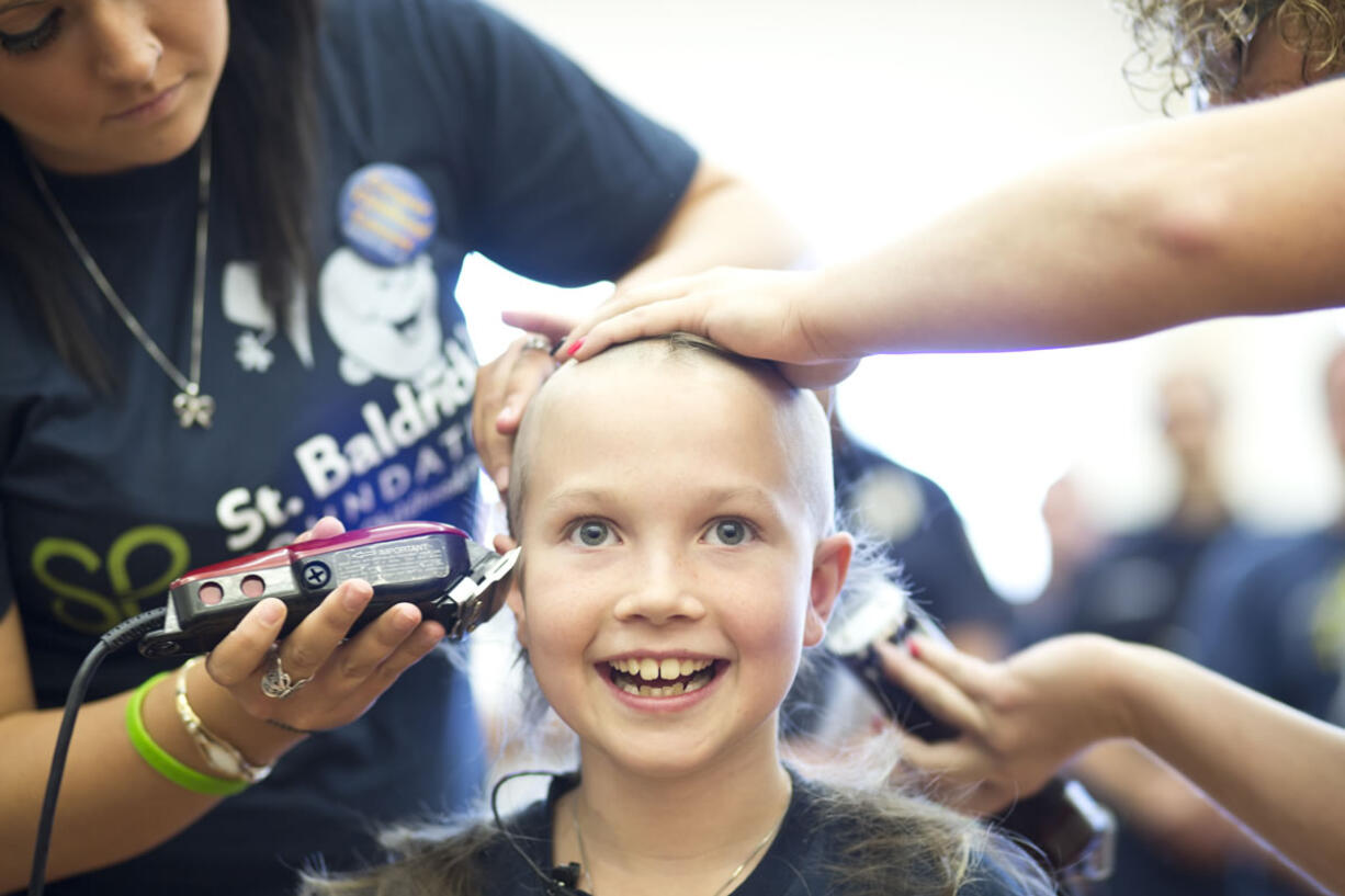 Sammy Mederos, a 9-year-old cancer survivor, gets her head shaved at a fundraiser for St. Baldrick's Foundation to fight childhood cancer.