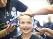 Sammy Mederos, a 9-year-old cancer survivor, gets her head shaved at a fundraiser for St. Baldrick's Foundation to fight childhood cancer.