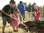 Using a gold shovel, Edvin Elguea, 9, a fourth-grader at Crestline Elementary School, helps his sister, Naobe, 2, shovel ceremonial dirt during the official groundbreaking at the construction site of the new Crestline Elementary School.