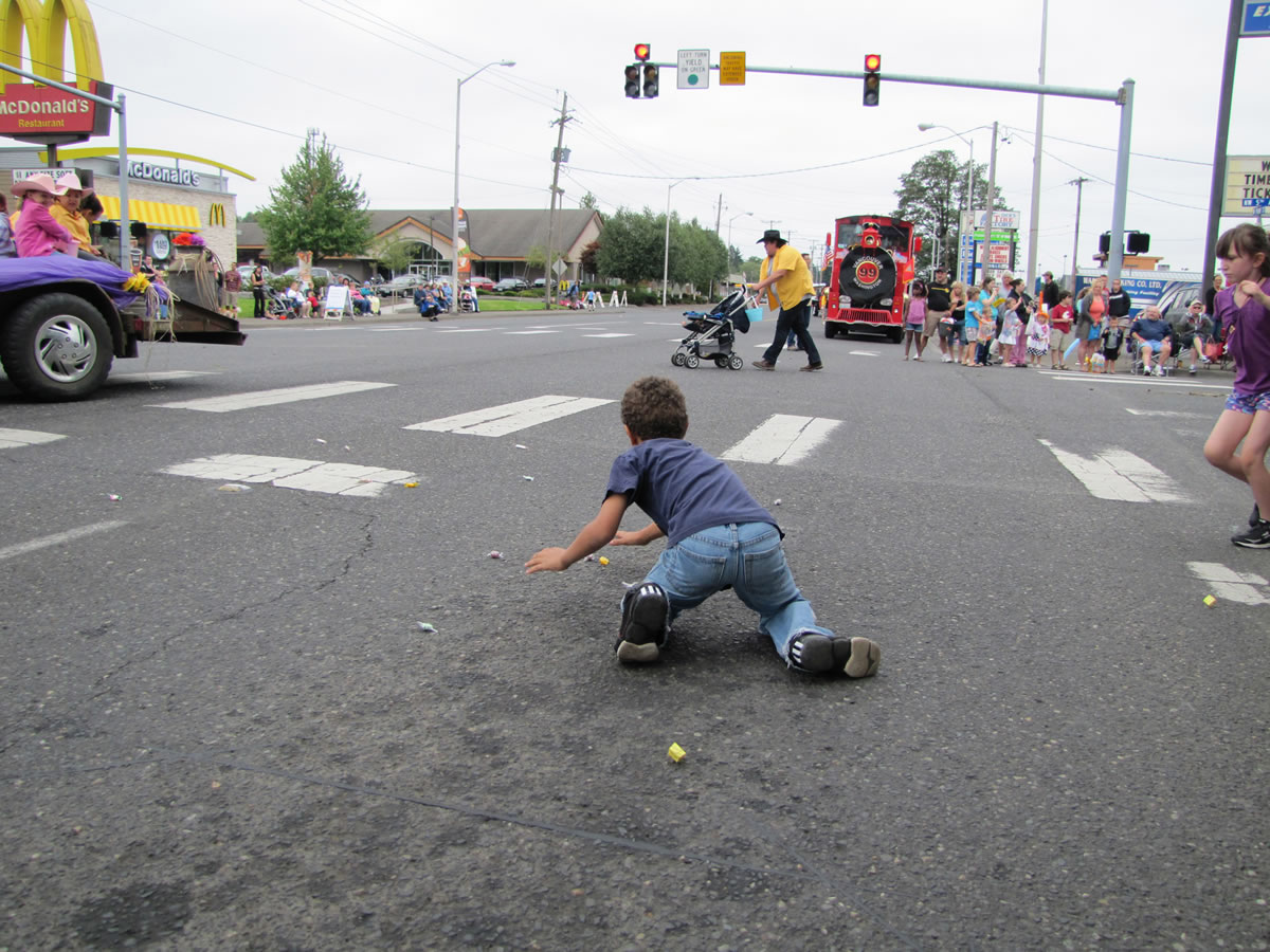 Stefanie Donahue/The Columbian 
 Brendon Adams leaps for candy at the Harvest Days parade on Saturday. His mother, Christi Adams, has taken her two kids to the parade for several years, she said.