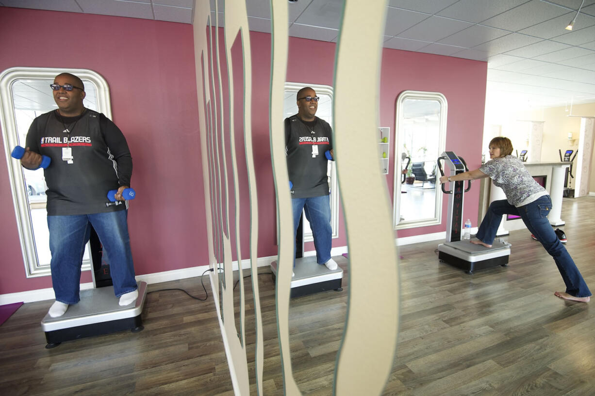 Pat Dixson, left, of Battle Ground and Jodi Carwan of Brush Prairie work out at Pro Vitae Vibration Studio in downtown Vancouver Monday.