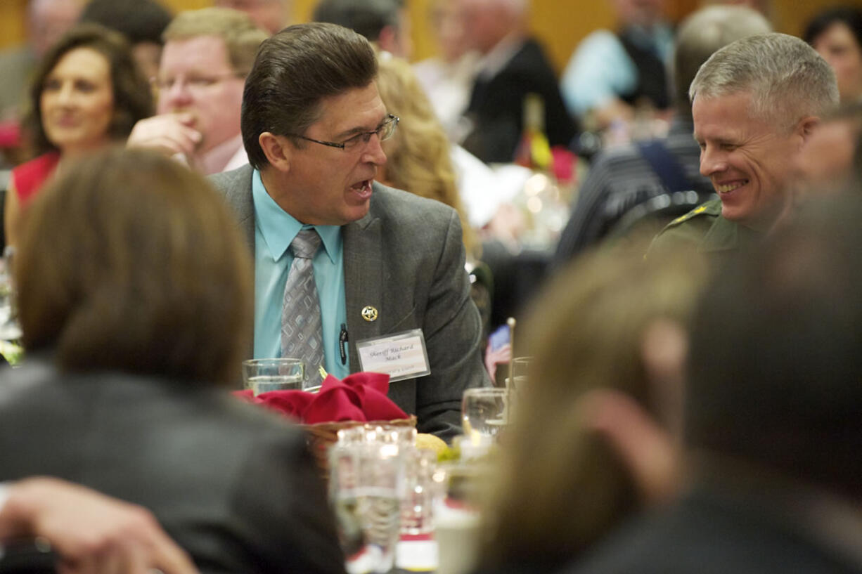 Keynote speaker Richard Mack, left, speaks with Linn County, Ore., Sheriff Tim Mueller at the Lincoln Day Dinner held at the Heathman Lodge on Saturday.