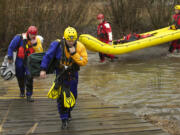 Rescue team members pull out of Salmon Creek after retrieving three young brothers whose kayak had overturned in the water and two members of a state prison work crew who went to the boys' aid.