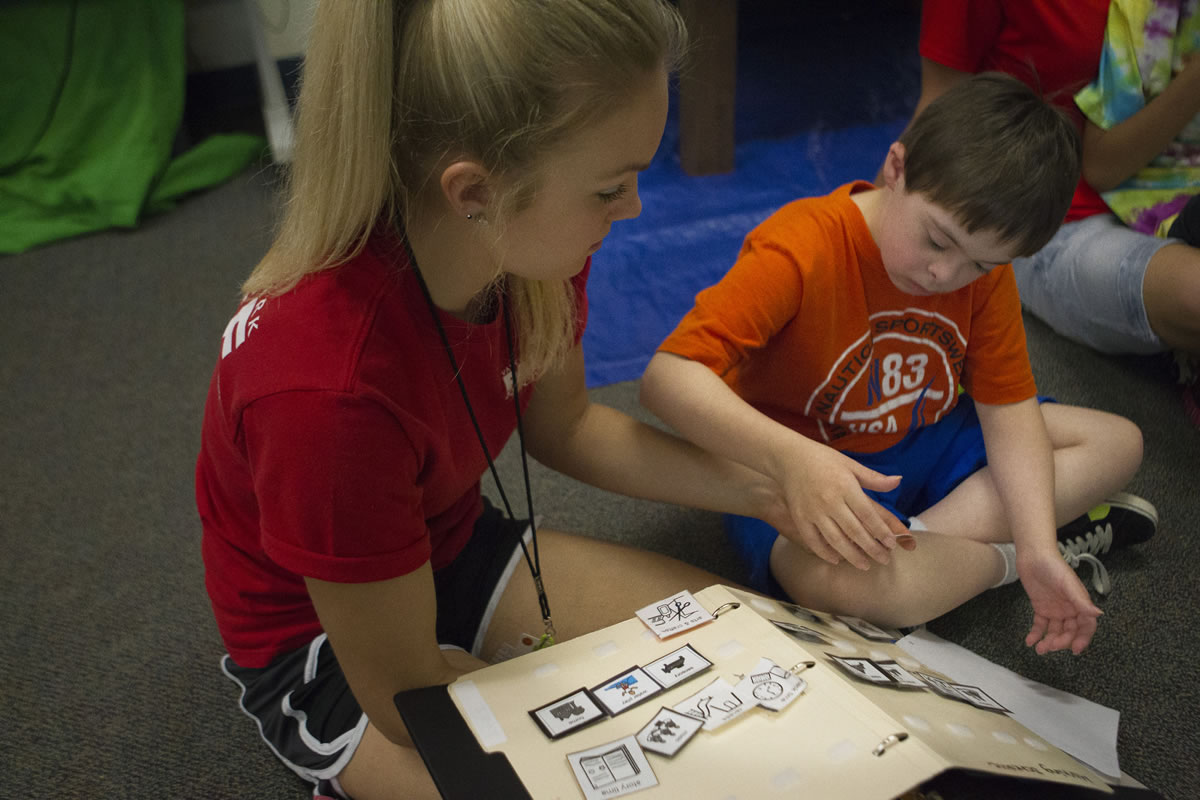 Jon Cook shows Tonja Cole what he would like to do next at Sensory Camp on Monday. The staff use visual cues to help children communicate their wants. &quot;I just enjoy these kids,&quot; said Cole.