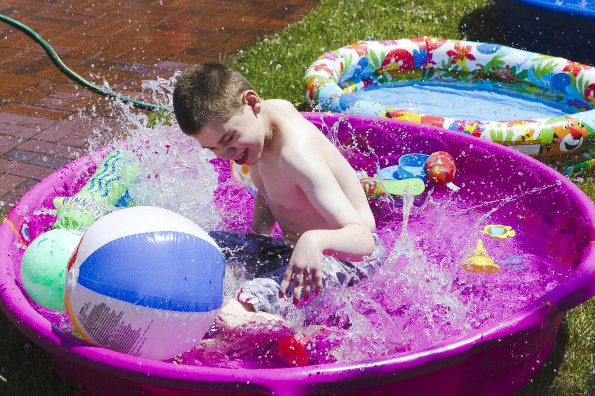 John McCulley splashes in the pools set up outside during water time Monday at Sensory Camp at Minnehaha Elementary School, the only public camp in the area designed for children with sensory integration disorders.