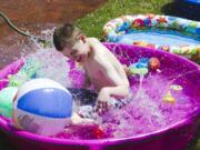 John McCulley splashes in the pools set up outside during water time Monday at Sensory Camp at Minnehaha Elementary School, the only public camp in the area designed for children with sensory integration disorders.