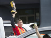 Vancouver Fire Department's Tom Cook collects a donation from a motorist on Northeast 78th Street near Interstate 5 in Hazel Dell on Thursday as part of &quot;Fill the Boot,&quot; which raises money for the Muscular Dystrophy Association.