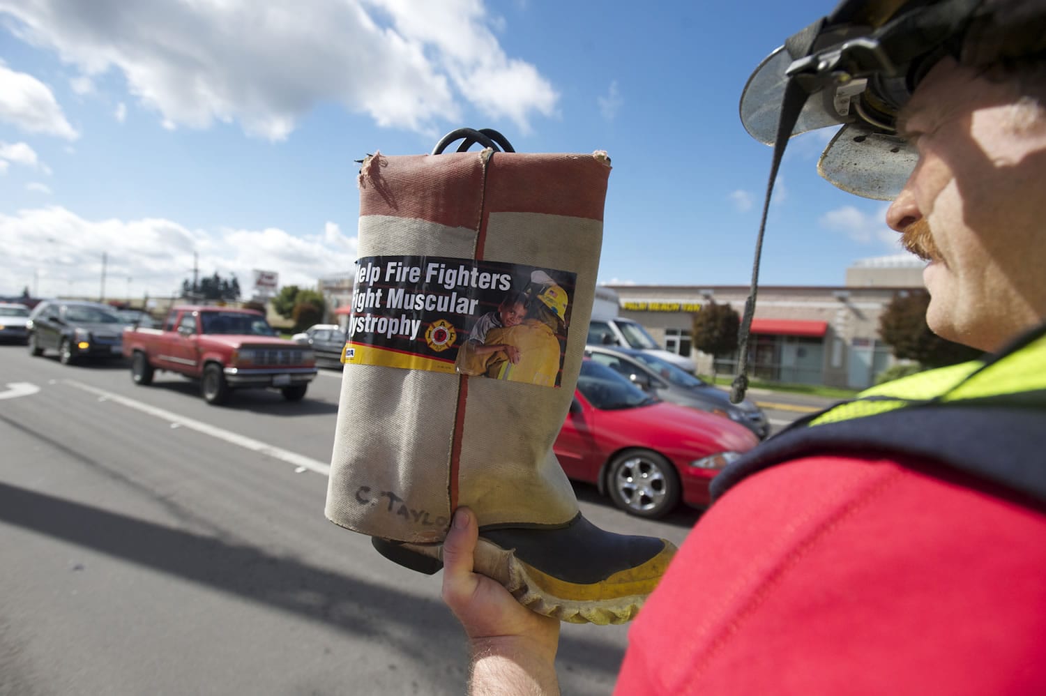 Clark County Fire District 6 firefighter Casey Taylor collects donations from motorists on 78th Street near Interstate 5 on Thursday for Fill the Boot, a nationwide event that raises money for the Muscular Dystrophy Association.