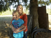 Paityn Mock, 10, and her mother, Jenn Mock, stand by the tree Paityn hid behind when burglars broke into their house in October.