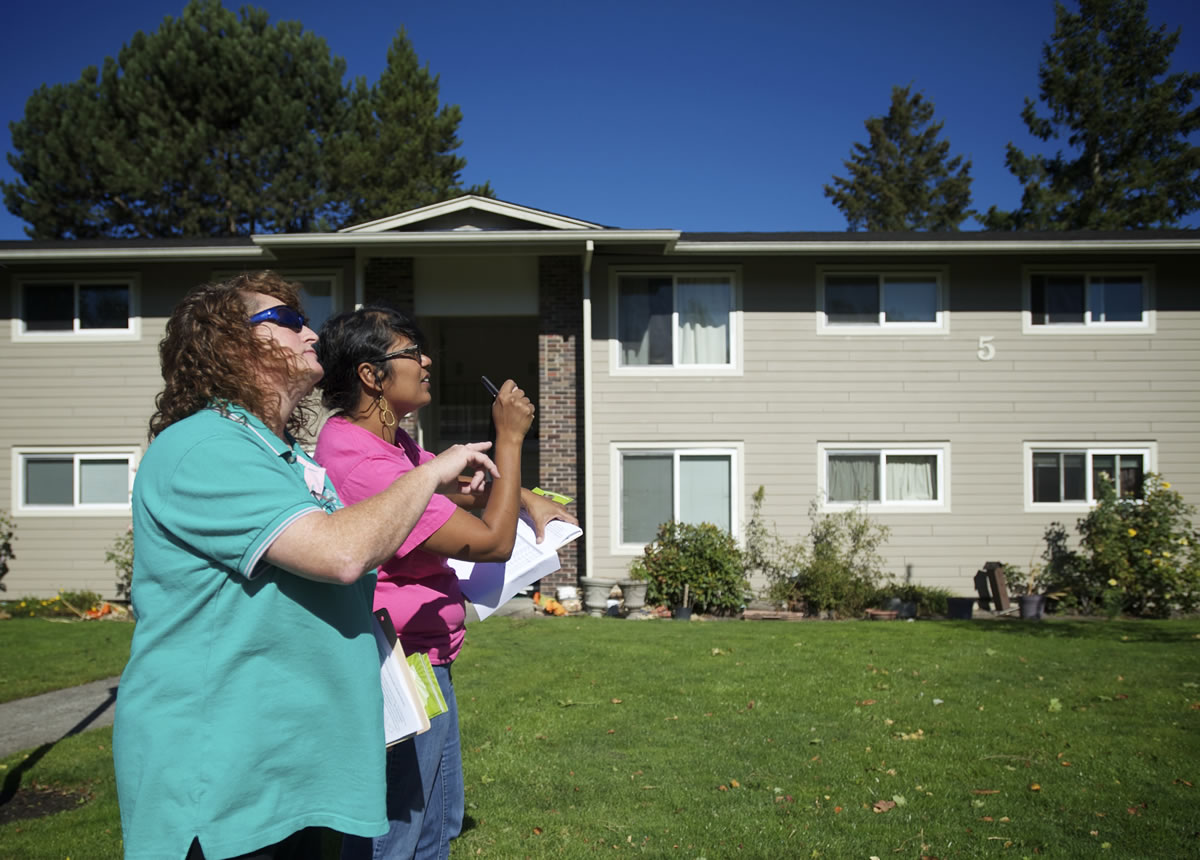 Same-sex marriage advocate Amy Wells, left, 51, of Vancouver, and Basic Rights Oregon Organizing Director Raahi Reddy, 40, of Portland, look for specific addresses inside an apartment complex in Hazel Dell as they canvass on Saturday.