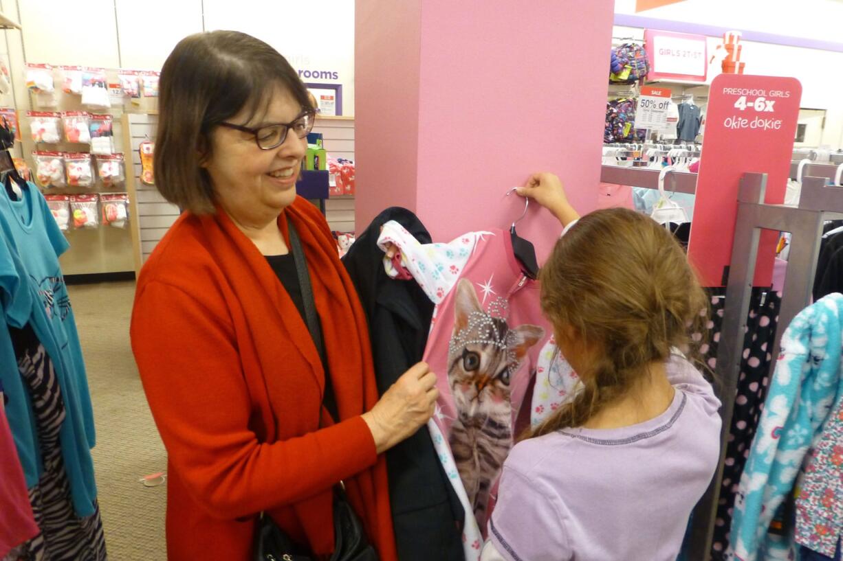 Vancouver Mall: Rotary Club of Greater Clark County member Jackie Spurlock visits with a young shopper Dec. 11 at the Santa&#039;s Clothes event.