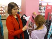 Vancouver Mall: Rotary Club of Greater Clark County member Jackie Spurlock visits with a young shopper Dec. 11 at the Santa&#039;s Clothes event.