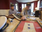 Keith Cupp, left, and dad Ted Cupp look over keepsakes from their service on the two USS Enterprise aircraft carriers. The two blue stars on the flag showed that Ted Cupp's family had two sons serving in World War II. Both brothers were at Iwo Jima, Ted said.