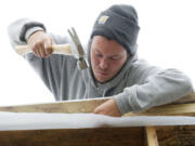 Thaddaeus Fronk, a student at the Clark County Skills Center, works on a Habitat for Humanity house built in partnership with Evergreen Public Schools.