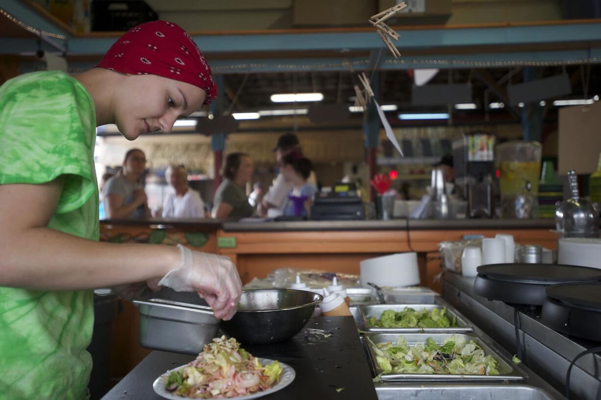 Saylor Green, 19, prepares a beet salad at the Fresh 4 You booth Wednesday at the Clark County Fair.