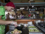 Saylor Green, 19, prepares a beet salad at the Fresh 4 You booth Wednesday at the Clark County Fair.