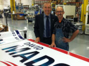 Sign of the times: Newly elected County Commissioner David Madore stands with sign-maker Michael Hurst a few weeks before election day.