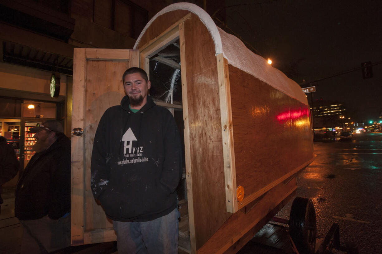 Jerad Nichols of Long Beach stands next to a hut he helped build through Huts for Hope during a visit Wednesday at Esther Short Park in Vancouver. The nonprofit group began building shelters for the homeless a year ago.