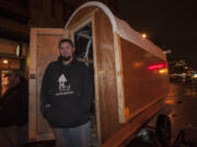 Jerad Nichols of Long Beach stands next to a hut he helped build through Huts for Hope during a visit Wednesday at Esther Short Park in Vancouver. The nonprofit group began building shelters for the homeless a year ago.