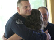 Vancouver police Officer Eric McCaleb gets a hug from Heidi Stewart, 18, after he received the Life Saving Award during a ceremony Thursday.