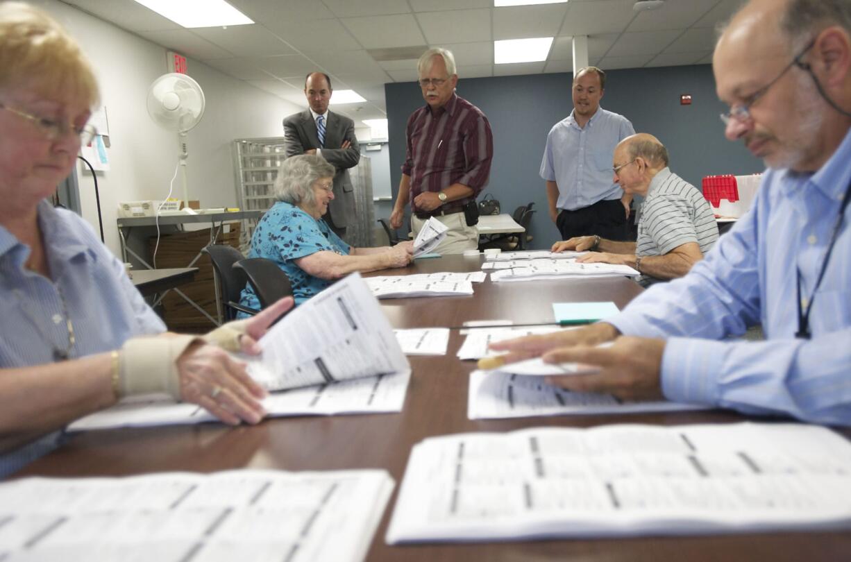 From back left: Clark County Auditor Greg Kimsey, Clark County Elections Supervisor Tim Likness and Clark County Elections Support Richard Cooper on Monday supervise Clark County Elections Department officials (from left) Janie Ledridge, Wanda Broadway, Bill Colvin and Brian Hopper conduct a recount for the tied Republican committee officer race in Precinct 965.