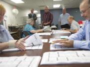 From back left: Clark County Auditor Greg Kimsey, Clark County Elections Supervisor Tim Likness and Clark County Elections Support Richard Cooper on Monday supervise Clark County Elections Department officials (from left) Janie Ledridge, Wanda Broadway, Bill Colvin and Brian Hopper conduct a recount for the tied Republican committee officer race in Precinct 965.