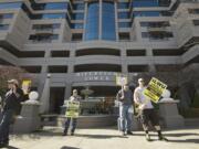 Picketers carry signs Thursday outside Riverview Tower in downtown Vancouver, where United Grain Corp.  has an office. The company locked out 44 International Longshore and Warehouse workers on Feb.