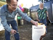 Michael and Cindy Johnson, Clark County's original Habitat family who first moved into their home in 1993, celebrate paying off their mortgage in full by burning copies of their loan papers during a ceremony at the Habitat offices on Friday.