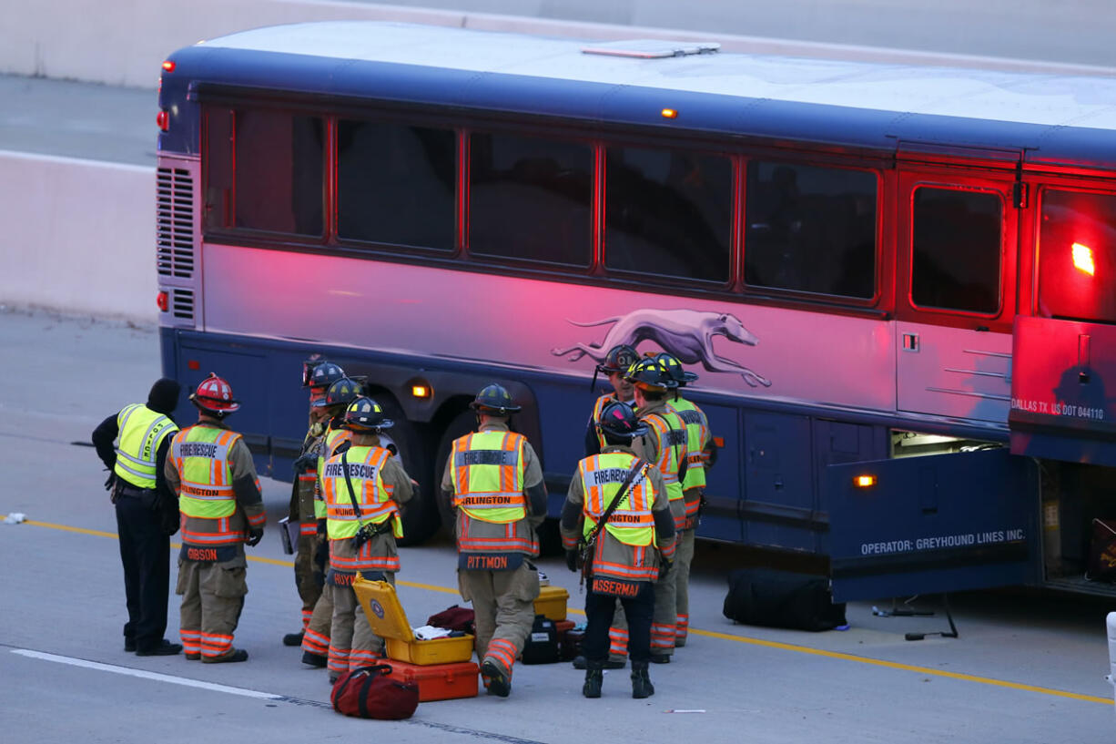 Arlington firefighters and police officers Sunday work an accident involving a Greyhound bus which struck a stalled SUV in the fast lane on westbound Interstate 30 near Collins St. in Arlington, Texas, early Sunday. A woman in the SUV died and 17 people were injured, authorities said.