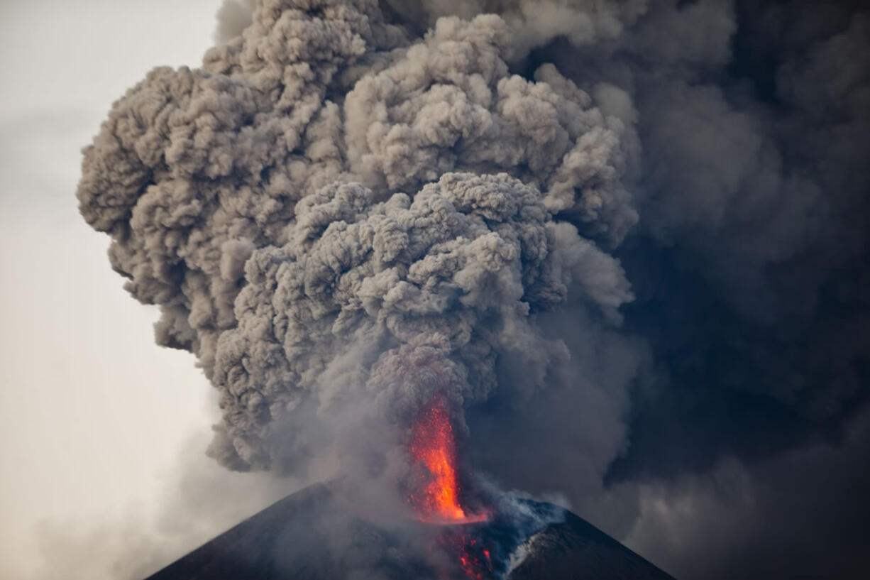 The Momotombo volcano spews a large plume of gas and ash Wednesday as seen from the rural community of Papalonal, in Leon, Nicaragua. Quiet for many years, the volcano emitted some glowing rock on Wednesday, after gas and ash emissions began Tuesday. In 1610, the city of Leon was destroyed during an eruption of the Momotombo and was relocated west.