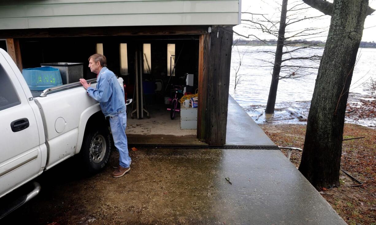 Charles York looks in his truck as he loads up items from the lower level of his river camp near Old Henderson Rd. in Evansville, Ind., on Monday before the rising Ohio River flooded the area. The storm system that spawned tornadoes in Texas over the weekend brought winter storm woes to the Midwest on Monday, worsening flooding already blamed for more than a dozen deaths and prompting hundreds of flight cancellations.