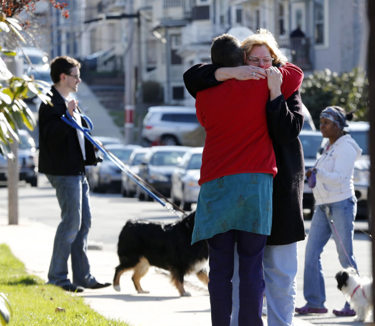 Neighbors hug outside the home of the Richard family in the Dorchester neighborhood of Boston on Tuesday.