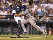 Milwaukee's Carlos Gomez smashes into Seattle catcher Humberto Quintero as Gomez scores in the seventh inning.