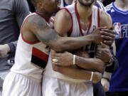 Portland Trail Blazers guard Damian Lillard, left, hugs teammate Nicolas Batum after winning an NBA basketball game against the Los Angeles Clippers in Portland, Ore., Saturday, Jan. 26, 2013.  Both players scored 20 points each as the Trail Blazers won 101-100.