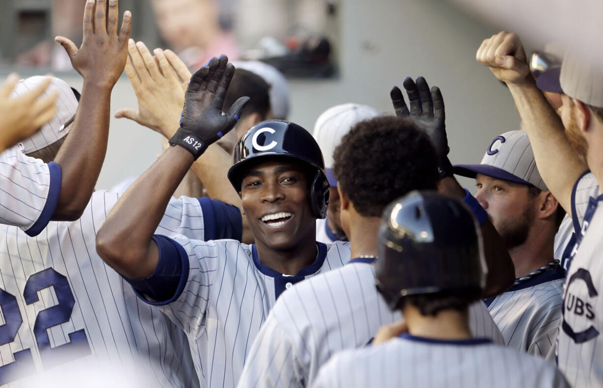 Chicago Cubs' Alfonso Soriano is congratulated in the dugout on his two-run home run against the Seattle Mariners in the 11th inning Saturday.