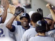 Chicago Cubs' Alfonso Soriano is congratulated in the dugout on his two-run home run against the Seattle Mariners in the 11th inning Saturday.