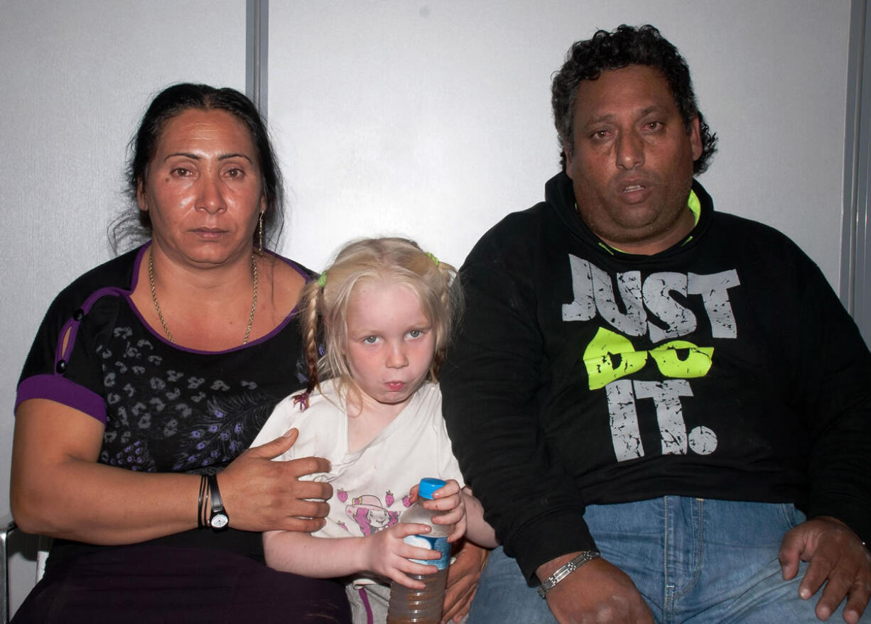 Christos Salis, 39, right, and his companion Eleftheria Dimopoulou, 40, or Selini Sali -- as the woman has two separate sets of identity papers -- pose with the little girl only known as &quot;Maria&quot; in the Larisa regional police headquarters, Greece.