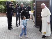 A child waves a flag as Pope Francis arrives Friday at Caritas Residence in Assisi, Italy.