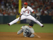 Seattle Mariners' Raul Ibanez, below, is forced out at second as Los Angeles Angels shortstop Erick Aybar throws out Mike Zunino at first during the fifth inning of their baseball game, Wednesday, June 19, 2013, in Anaheim, Calif.  (AP Photo/Mark J.