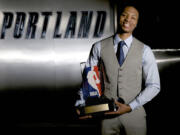 Portland Trail Blazers guard Damian Lillard poses with the trophy after being named NBA basketball's Rookie of the Year on Wednesday, May 1, 2013, in Portland, Ore. Lillard also swept all six of the league's Rookie of the Month awards this season.