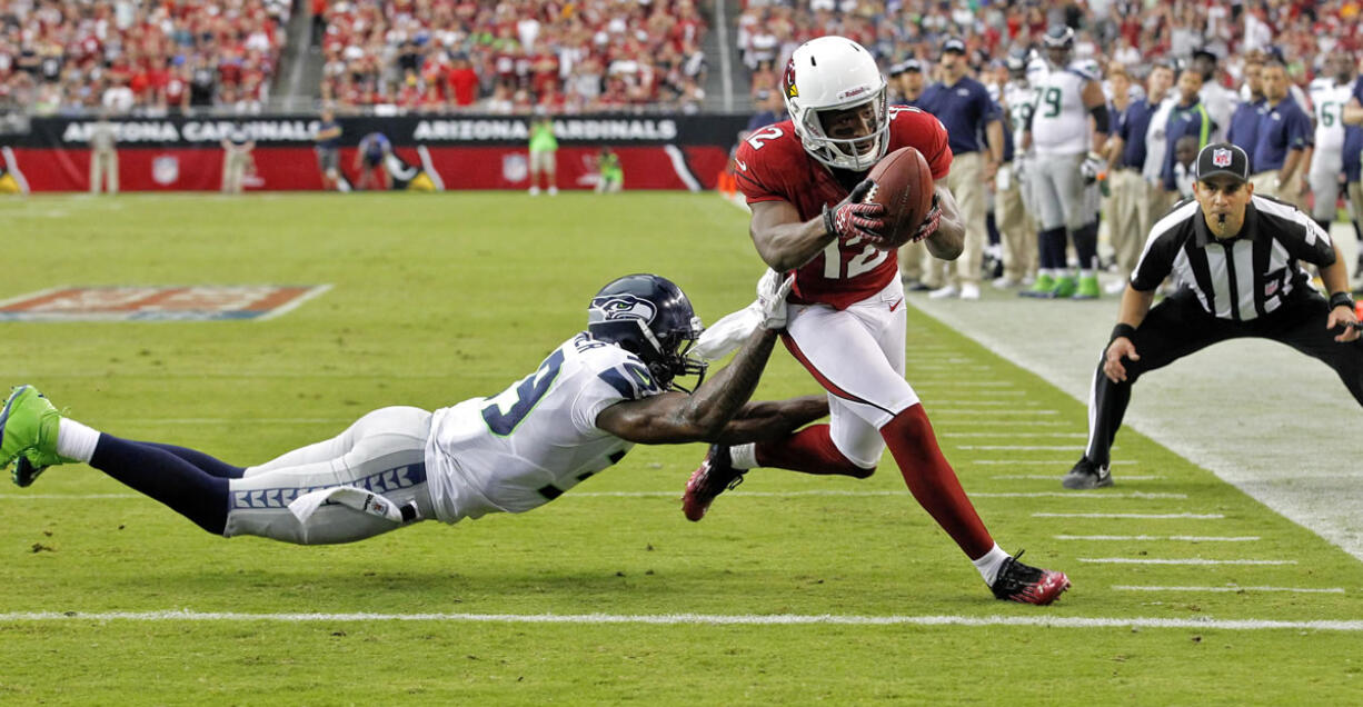 Arizona Cardinals wide receiver Andre Roberts (12) scores a touchdown as Seattle Seahawks cornerback Brandon Browner defends during the second half Sunday.