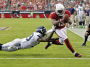 Arizona Cardinals wide receiver Andre Roberts (12) scores a touchdown as Seattle Seahawks cornerback Brandon Browner defends during the second half Sunday.