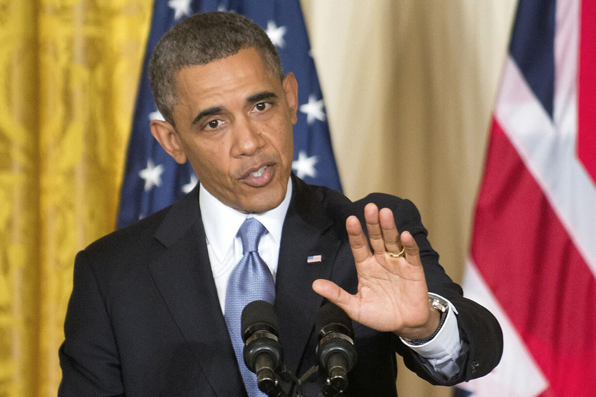 President Barack Obama gestures during a joint news conference with British Prime Minister David Cameron on Monday in the East Room of the White House in Washington.