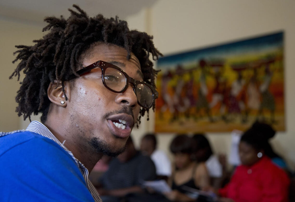 Americorps volunteer John Harris III, who is helping to coordinate a jobs fair program, talks to job seekers in Washington on Wednesday.