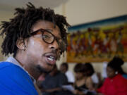 Americorps volunteer John Harris III, who is helping to coordinate a jobs fair program, talks to job seekers in Washington on Wednesday.